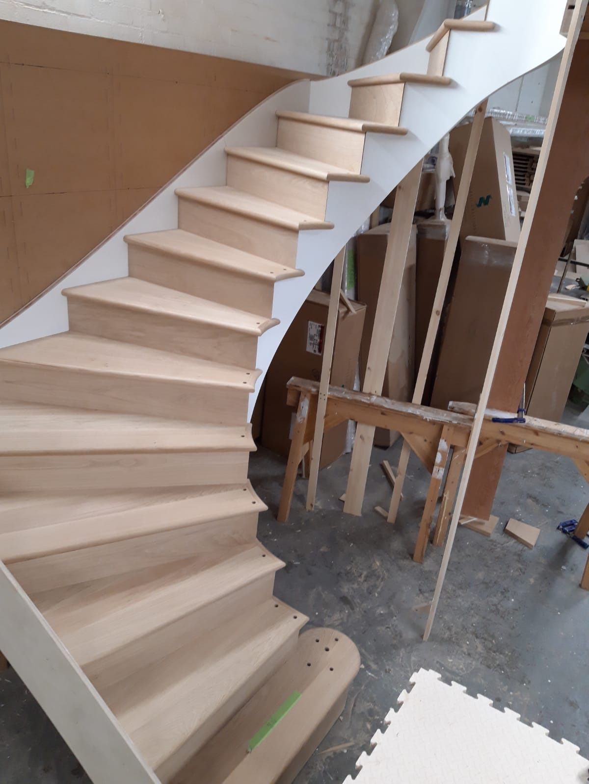 Curved staircase with a white stringer in the workshop