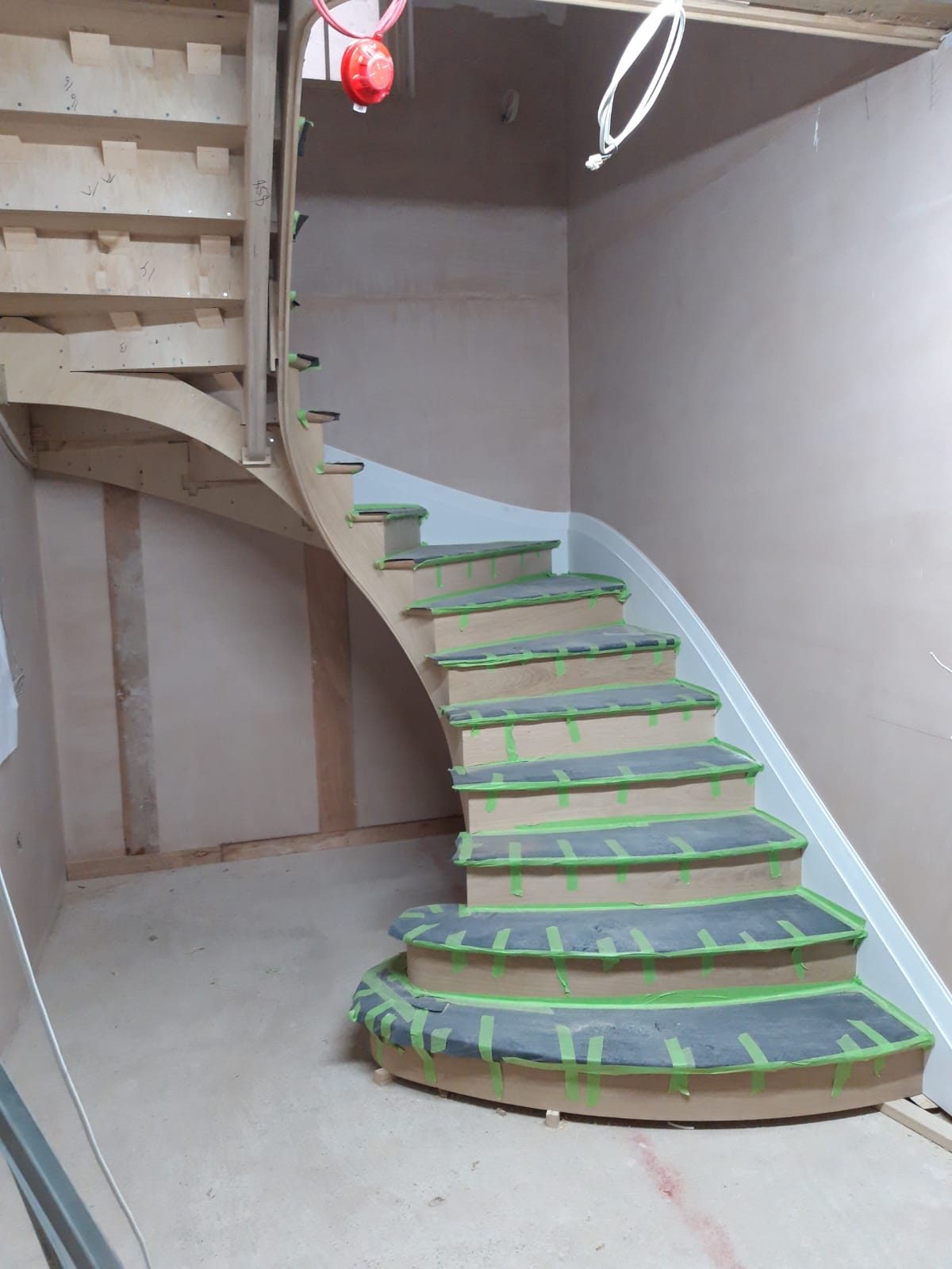 Curved staircase fitted, treads protected before finishing