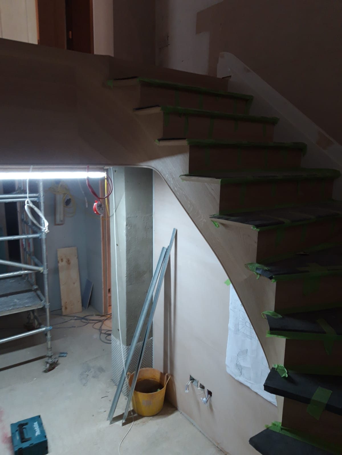 Curved staircase with dark treads during fitting