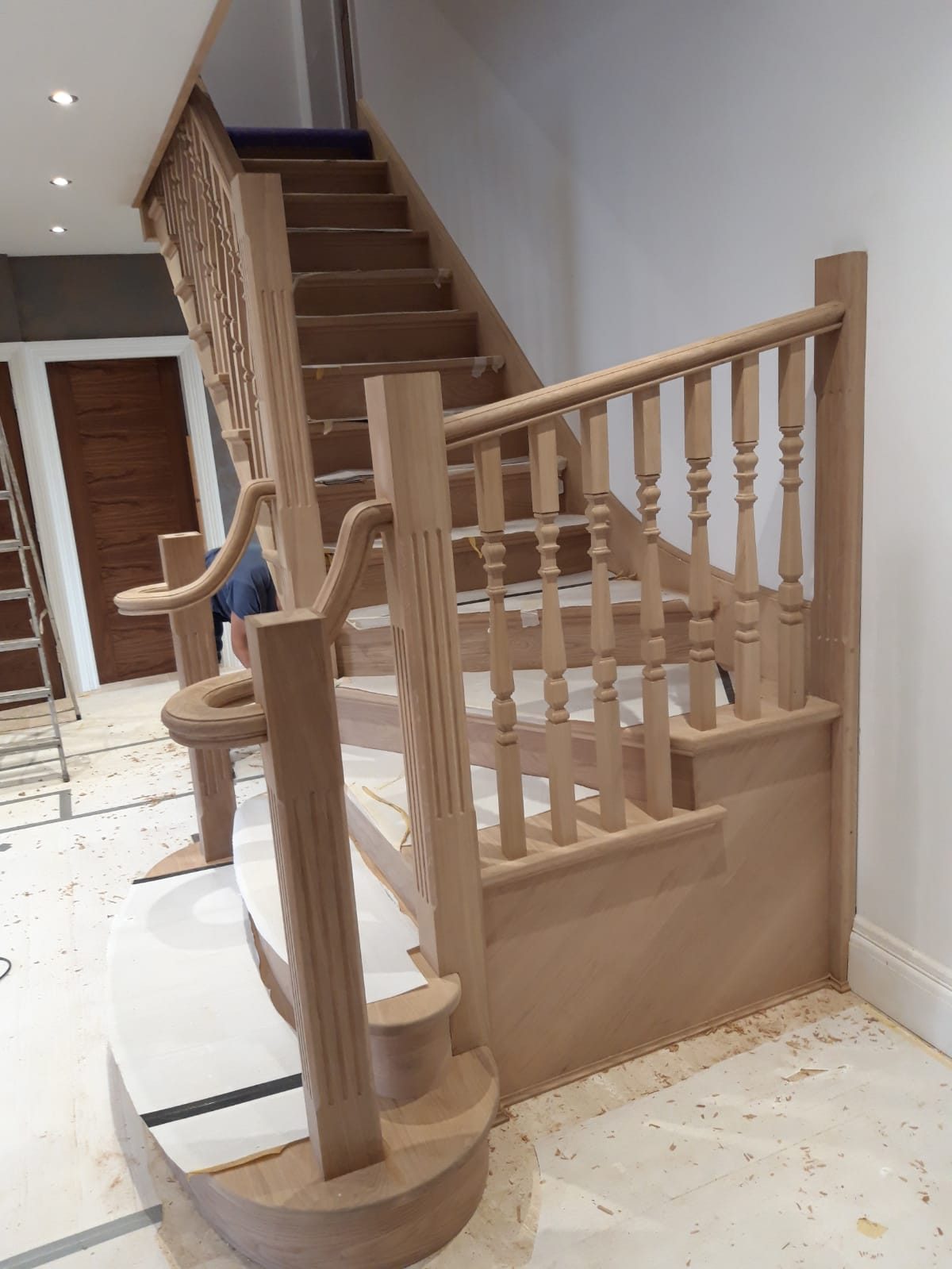 Oak staircase with turned spindles and a curved bottom step