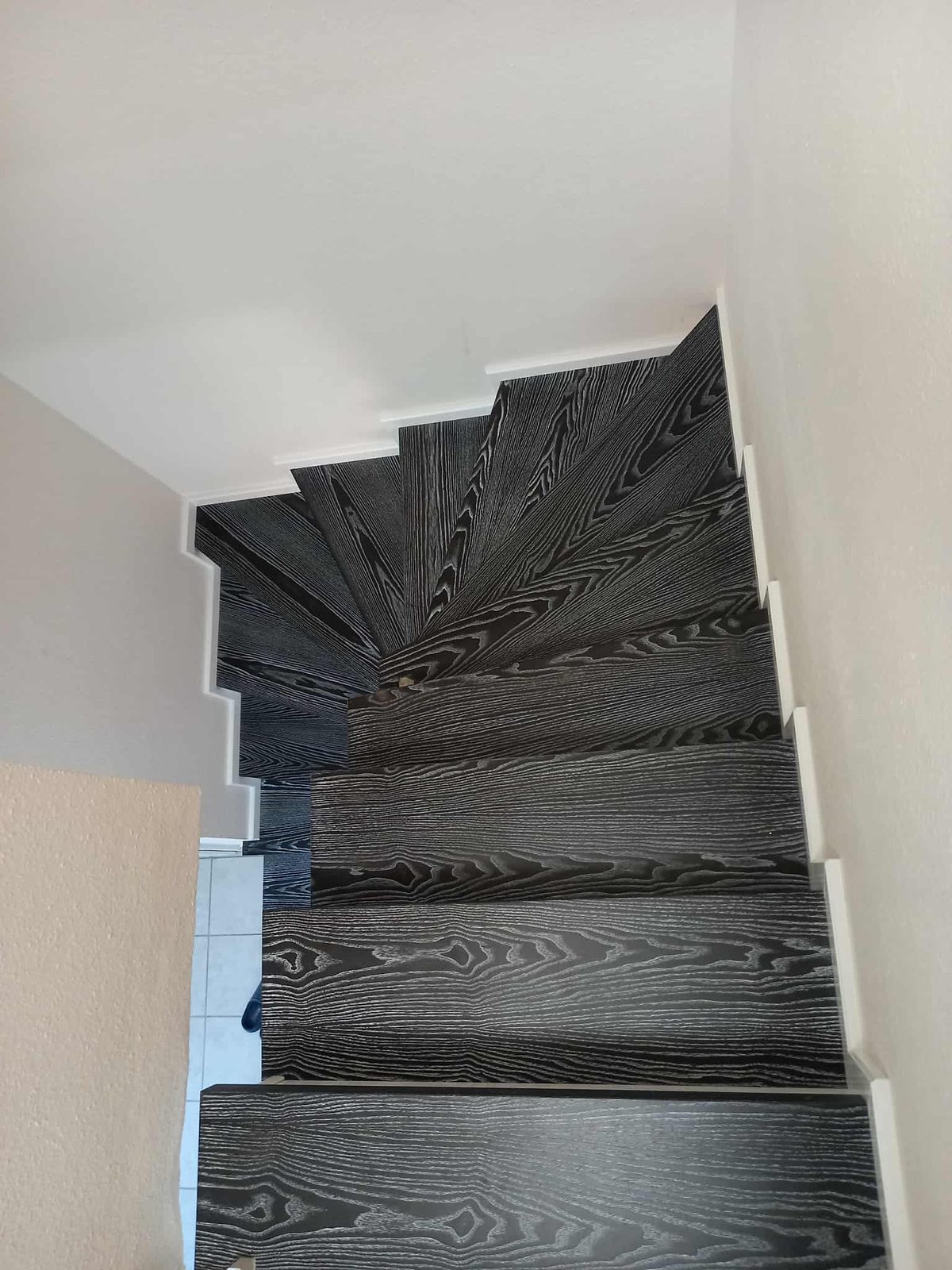 Winding staircase with dark brushed-oak treads