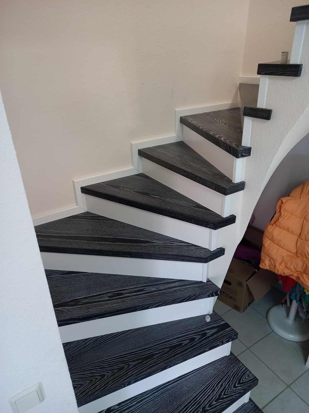Dark brushed-oak treads on a white winding staircase