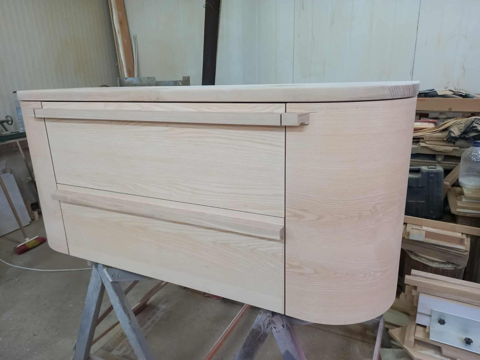 Curved ash cabinet with handle-less drawers