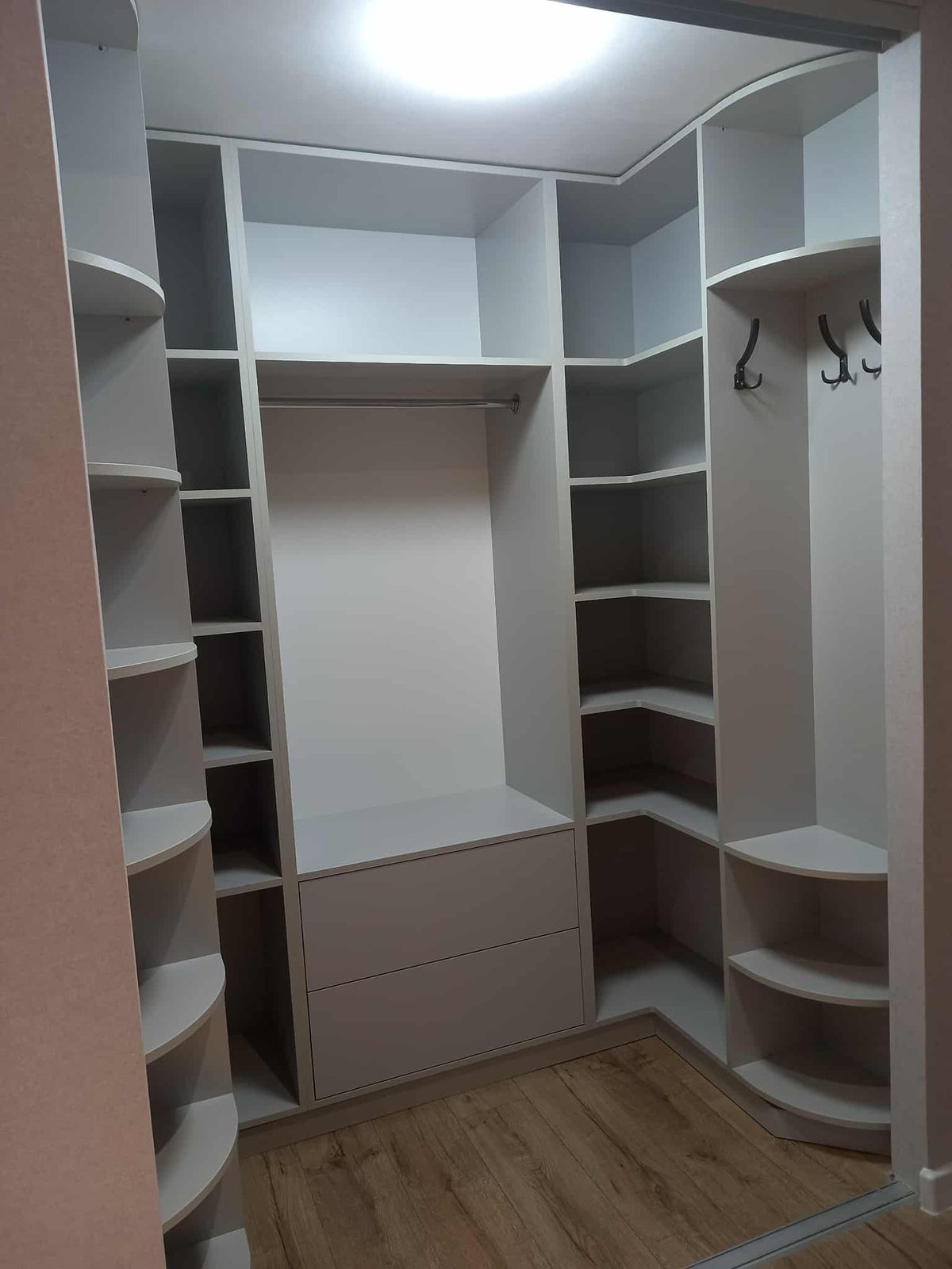 Walk-in wardrobe with curved corner shelves
