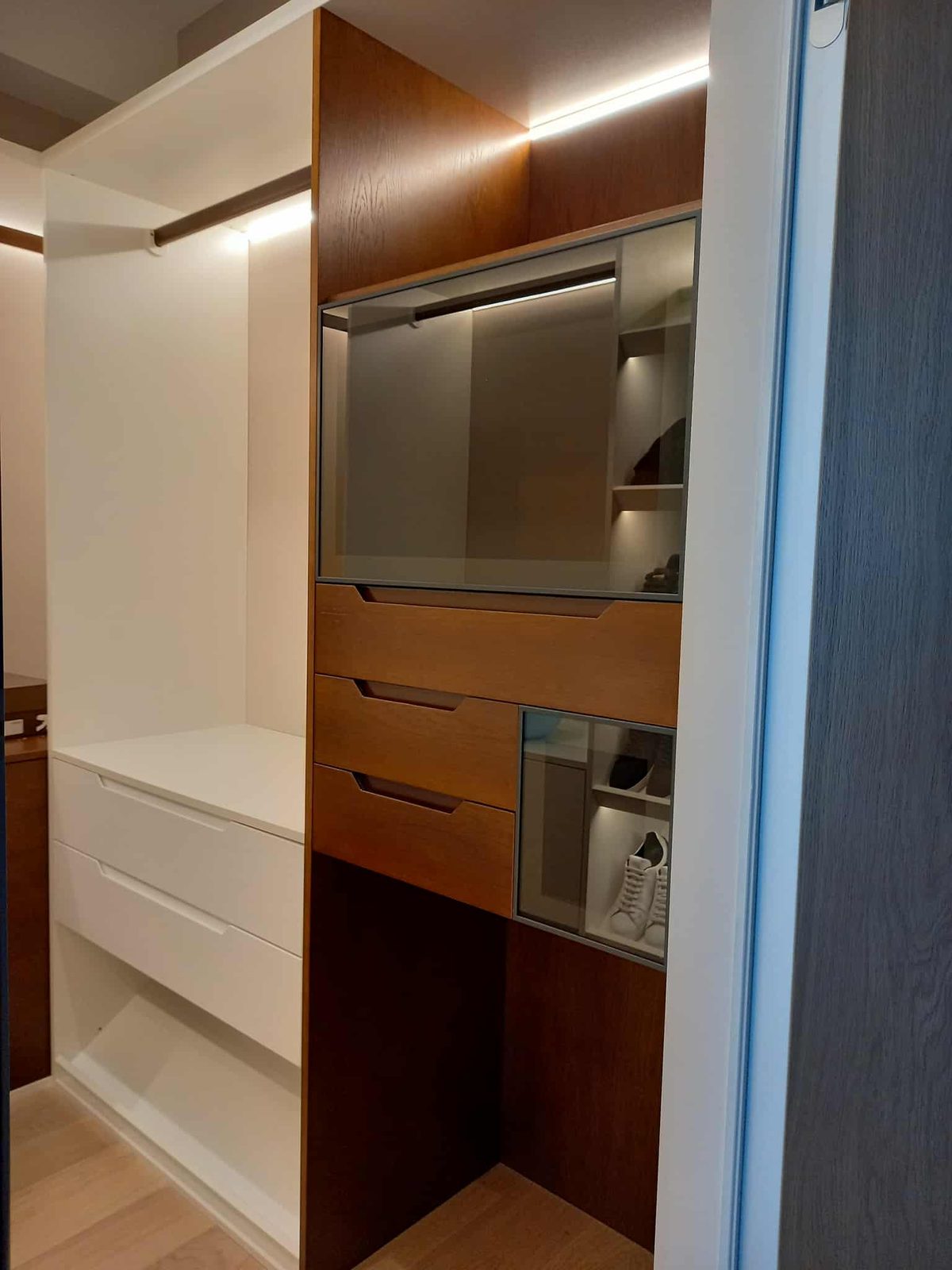 Fitted walnut and white wardrobe unit with lighting